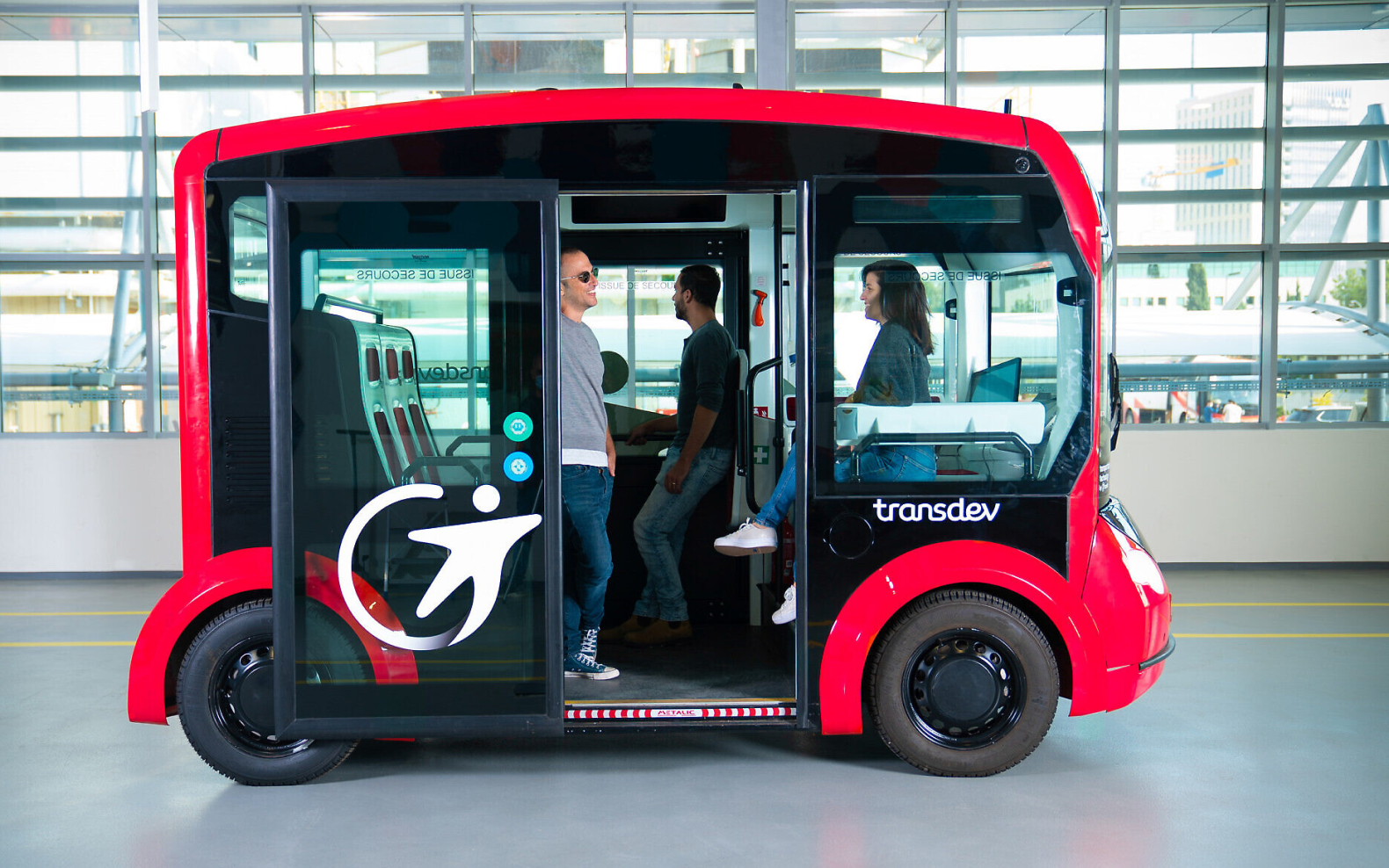 A public shuttle transport named Transdev Autonomous Transport System carrying people for the tour.